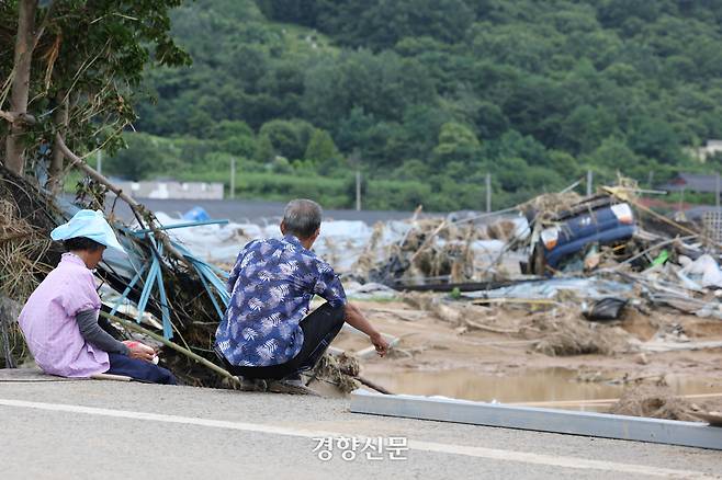 경남 산청군 신안면 주민들이 20일 무너지고 폭우에 휩쓸려간 집터와 뒤집힌 차량을 바라보고 있다. 한수빈 기자