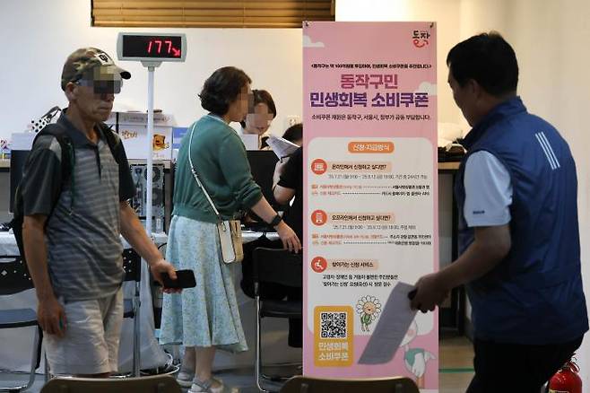민생회복 소비쿠폰 1차 신청이 시작된 21일 서울 동작구 대방동주민센터에서 주민들이 선불카드를 신청하고 있다. 성동훈 기자