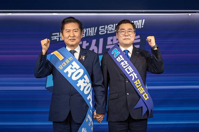 더불어민주당 대표 선거에 출마한 정청래(왼쪽), 박찬대 후보가 지난 19일 서울 여의도 당사에서 열린 합동연설회에서 함께 주먹을 쥐며 인사하고 있다.  [더불어민주당 제공]