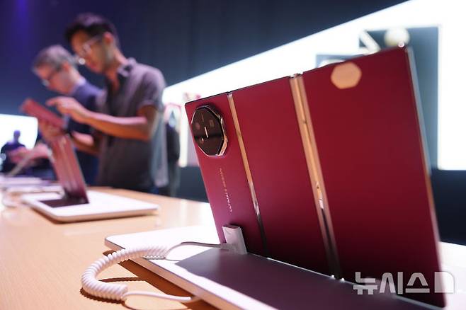 [쿠알라룸프=AP/뉴시스] 중국 최대 통신장비 제조업체 화웨이가 세계 최초 두 번 접히는 트리플 폴더블(3단폰)을 해외 시장에서 판매하기 시작했다. 18일(현지 시간) 말레이시아 쿠알라룸프에서 열린 화웨이 신제품 공개행사에서 사람들이 화웨이 트리플 폴더블폰 ‘메이트XT’을 살펴보는 모습. 2025.02.19