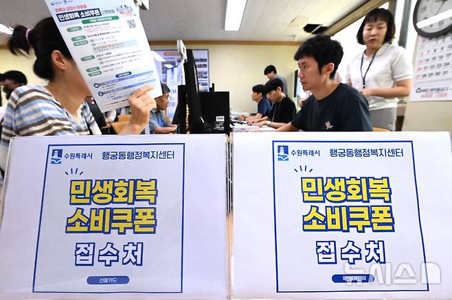 [수원=뉴시스] 김종택 기자 = 정부의 민생회복 소비쿠폰 1차 신청 첫날인 21일 경기 수원시 행궁동 행정복지센터에서 시민들이 지원금을 신청하고 있다. 소비쿠폰 신청은 요일제에 따라 출생 연도 끝자리 1·6은 월요일, 2·7은 화요일, 3·8은 수요일, 4·9는 목요일, 5·0은 금요일에 신청할 수 있다. 주말에는 온라인 신청만 가능하며 사용기한은 11월 30일까지다. 2025.07.21. jtk@newsis.com