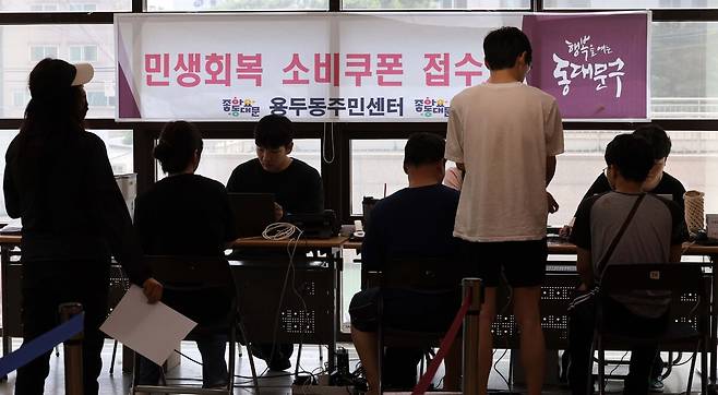 시민들이 21일 서울 동대문구 용두동 주민센터에서 민생회복 소비쿠폰 카드를 발급받고 있다.&nbsp;허정호 선임기자