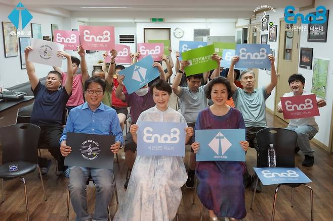 유시연 숙명여대 교수(가운데)와 봉사자, 관객이 사단법인 이노비 보드를 들고 기념사진을 찍고 있다. (이노비 제공)