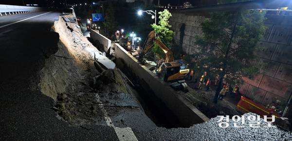 수도권 지역에 호우주의보가 내려지는 등 많은 비가 내린 지난 16일 오후 7시4분께 오산시 가장교차로 고가도로의 옹벽이 무너지는 사고가 발생했다. 이 사고로 차량 운전자 40대 A씨가 심정지 상태로 구조돼 인근 병원으로 이송됐으나 숨졌다. 사진은 사고 현장에서 소방관들이 매몰된 차량을 구조하는 모습. 2025.7.16 /최은성기자 ces7198@kyeongin.com