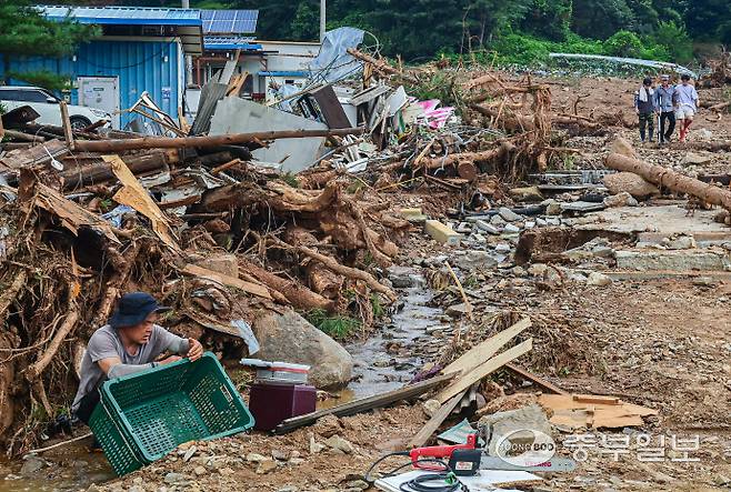 산사태 피해 주민이 21일 오후 가평군 조종면 신상리 산사태 현장에서 바구니에 뭍은 토사를 닦아내고 있다. 임채운기자
