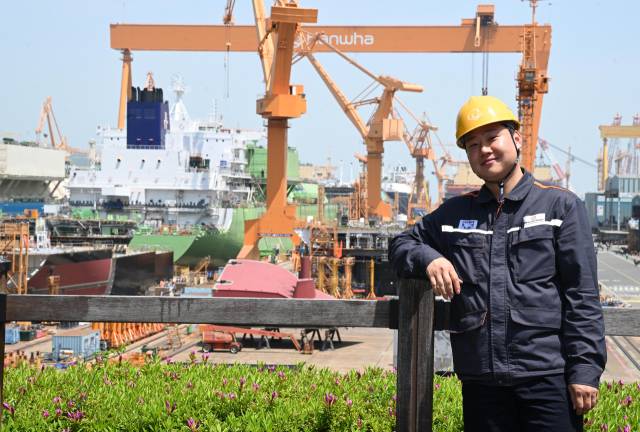 한화오션 신입사원 장민씨가 조선소를 배경으로 포즈를 취하고 있다./성승건 기자/