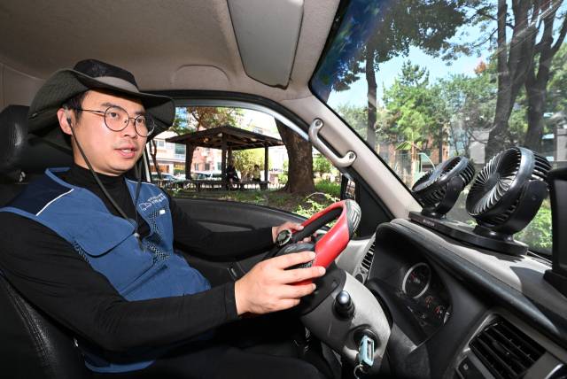 폭염주의보가 내린 22일 창원시 진해구 석동 일대에서 이준석 택배기사와 차량 내 설치된 선풍기로 더위를 식히고 있다./성승건 기자/