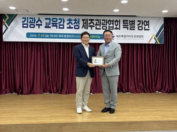 김광수 제주도교육감(왼쪽)이 강동훈 제주도관광협회장으로부터 감사패를 받고 있다.