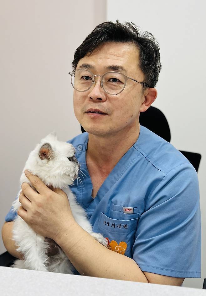 차진원 수의사가 동물병원에서 구조해 기르는 고양이와 함께 사진을 찍고 있다. ⓒ 뉴스1