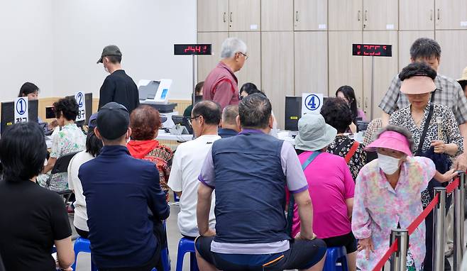 민생회복 소비쿠폰 1차 신청 둘째 날인 22일 서울 강동구 암사 1동 주민센터를 찾은 시민들이 소비쿠폰 신청을 기다리고 있다. /뉴스1