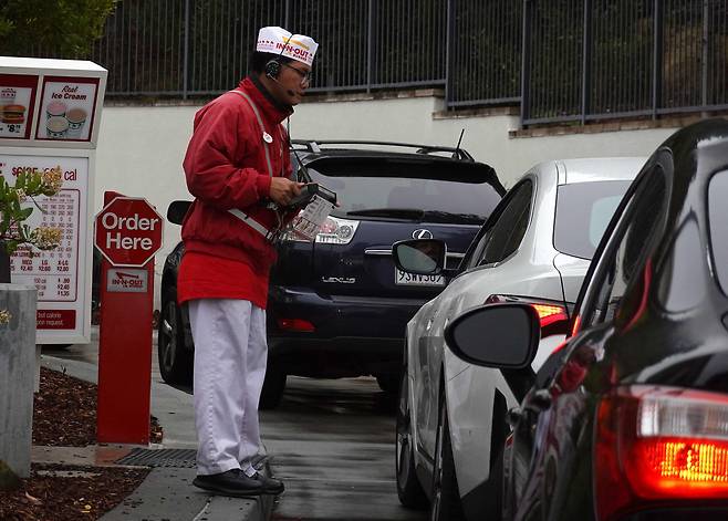 2025년 7월 21일 캘리포니아주 데일리 시티의 인앤아웃 버거 레스토랑 드라이브스루에서 직원이 주문을 받고 있다. /연합뉴스