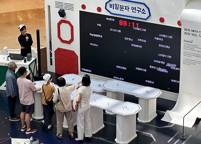 22일 스타필드 고양점에서 열린 '무림 페이퍼어드벤처'에서 '비밀 암호풀기' 체험을 하는 관람객들. 사진=서지윤 기자