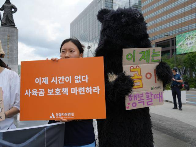 반달가슴곰 인형 탈을 쓴 활동가가 사육곰 보호 정책을 촉구하는 손팻말을 들고 있다. 동물자유연대 제공