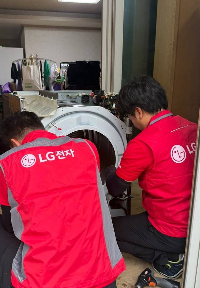 수해 복구 현장에서 가전 제품을 수리 중인 LG전자 직원들. 사진=LG전자
