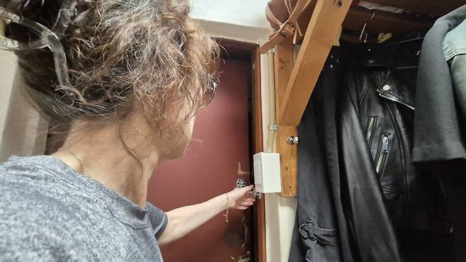 서울 중구 남대문쪽방촌에 거주하는 여성 A씨가 자신의 방에 설치된 안전고리를 이용해 문을 열고 있다.