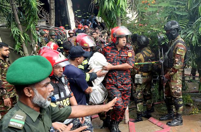 방글라데시에서 공군 훈련기가 이륙직후 기술적 오작동을 일으켜 학교 건물에 추락해 약 200명의 사상자가 발생했다. 사진은 21일(현지시각) 방글라데시 다카의 마일스톤 칼리지 캠퍼스에 공군 훈련기가 추락한 후 소방관과 군인들이 희생자를 운구하는 모습. /사진=로이터