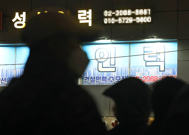 새벽 인력사무소가 밀집한 서울 남구로역 인근에서 일감을 구하려는 일용직 구직자들 뒤로 인력사무소의 불이 켜져 있다. [연합]