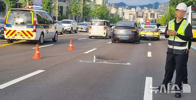 [광주=뉴시스] 22일 오후 5시30분께 광주 서구 쌍촌역 인근 도로에서 땅꺼짐 현상(싱크홀)이 발생해 당국이 안전 조치를 하고 있다. (사진=독자 제공) 2025.07.22. photo@newsis.com