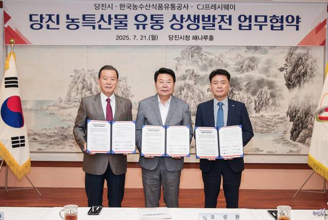 21일 충남 당진시청에서 ‘당진 농특산물 유통 상생발전 업무협약식’이 열렸다. 홍문표 aT 사장, 오성환 당진시장, 강연중 CJ프레시웨이 급식사업본부장이 협약서를 들어보이고 있다. CJ프레시웨이