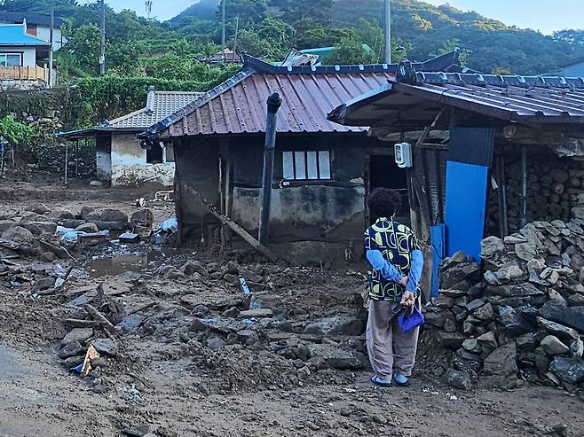 22일 경남 산청군 율현마을 산사태 실종자의 아내 전인호 씨(74)가 자신의 집과 주변을 살펴보며 실종된 남편을 찾고 있다. 뉴스1