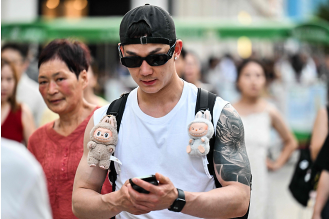 한 중국 남성이 가방에 라부부 인형을 단 채 길을 걷고 있다. 상하이 AFP 연합뉴스