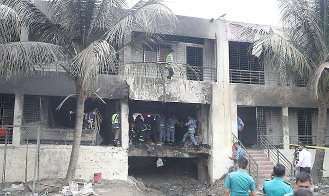 방글라데시 다카의 마일스톤 스쿨 앤드 칼리지 캠퍼스에 공군 훈련기가 추락한 사고 이튿날인 22일(현지시간) 공군과 수사기관 관계자들이 사고 현장을 조사하고 있다. 2025.7.22 EPA 연합뉴스