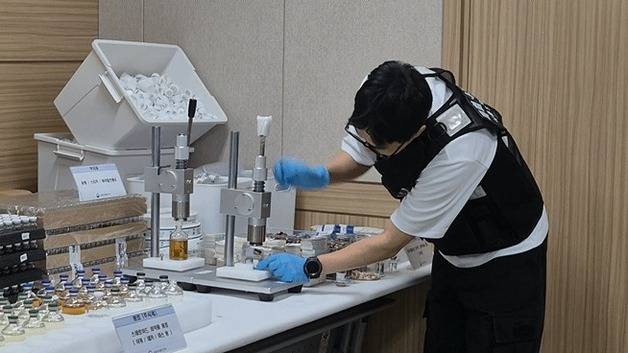 식품의약품안전처 위해사범중앙조사단 수사관이 22일 서울지방식약청에서 열린 브리핑에서 불법 의약품 제조 과정을 시연하고 있다. /뉴스1