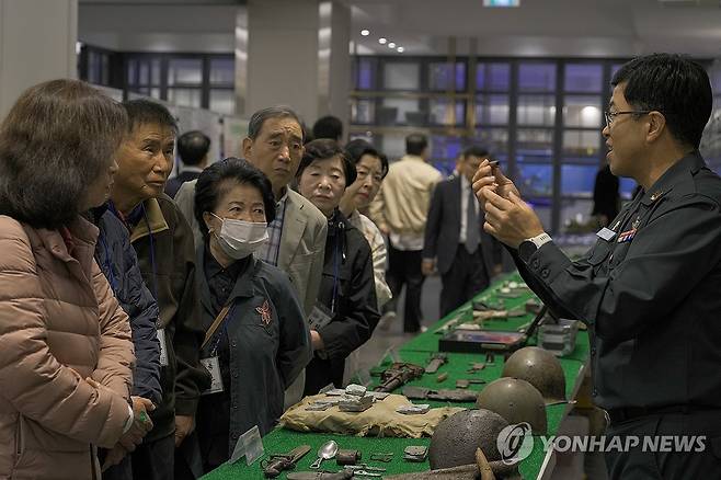 24년 후반기 6.25전사자 유해발굴 사업설명회 (서울=연합뉴스) 국방부유해발굴감식단 관계자가 24일 인천광역시 카리스호텔에서 열린 인천·경기 지역 6·25 전사자 유해발굴사업 설명회에서 유가족들에게 전시된 발굴 사진과 유품을 설명하고 있다. 2024.10.24 [국방부 제공. 재판매 및 DB 금지] photo@yna.co.kr