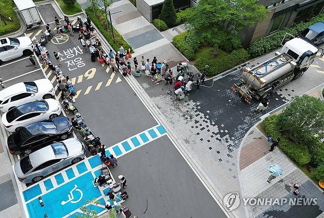 줄 서서 물 받는 아파트 주민들 (울산=연합뉴스) 김용태 기자 = 21일 이틀째 단수가 이어지고 있는 울산시 울주군 언양읍 한 아파트 주민들이 살수차에서 물을 받아 가기 위해 줄을 서 있다. 울산시 상수도사업본부에 따르면 지난 19일 내린 호우로 상수도 송수관로가 파손된 영향으로 지난 20일 오전부터 울주군 6개 읍·면 지역에 수돗물 공급이 중단됐다. 2025.7.21 yongtae@yna.co.kr