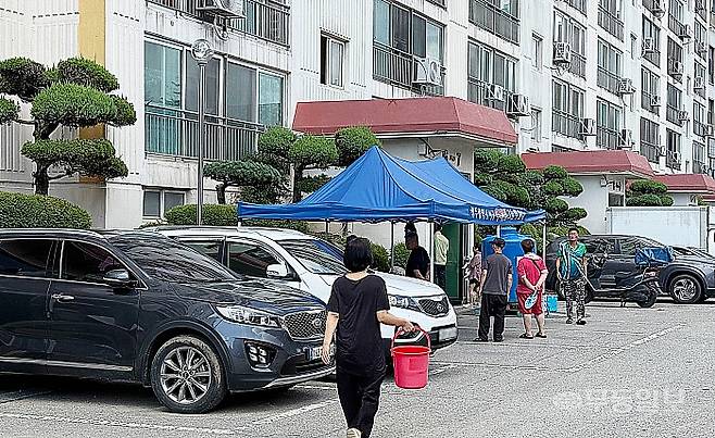 지난 22일 오후 광주 서구 유덕동 동남아파트. 한 주민이 생활용수를 받으러 가고 있다.