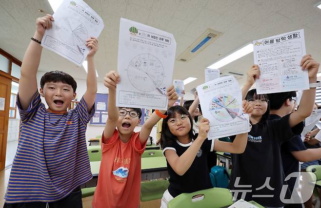 23일 서울 동작구 삼일초등학교에서 열린 여름 방학식에서 학생들이 여름방학 계획표를 들어보이며 기뻐하고 있다. 2025.7.23/뉴스1 ⓒ News1 박지혜 기자