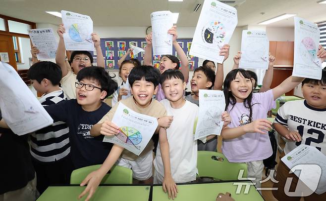 23일 서울 동작구 삼일초등학교에서 열린 여름 방학식에서 학생들이 여름방학 계획표를 들어보이며 기뻐하고 있다. 2025.7.23/뉴스1 ⓒ News1 박지혜 기자