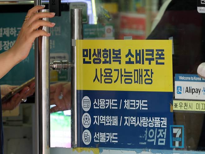 민생회복 소비쿠폰 1차 신청 첫 날인 21일 서울의 한 편의점에 쿠폰 사용 관련 안내문이 붙어있다./뉴스1