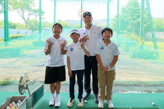 문동현 선수가 ‘드림라운드’에 참석한 학생들과 레슨 후 기념촬영을 하고 있다. [우리금융그룹 제공]