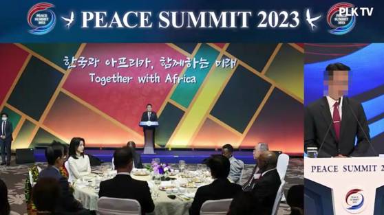 지난해 5월 서울 잠실 롯데호텔월드에서 열린 피스 서밋(PEACE SUMMIT) 2023 개회식에서 윤모 당시 통일교 세계본부장이 2022년 11월 아프리카 대사단 초청 만찬에서 연설하는 윤석열 전 대통령과 자리에 앉은 김건희 여사 사진을 띄워놓고 개회사를 하고 있다. 사진 독자 제공