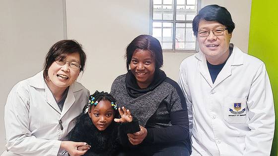 '2025 JW성천상' 수상자인 강동원(맨 오른쪽)·전진경 부부 의사가 22일 짐바브웨 현지 진료실에서 소아 뇌성마비 환자를 만났다. 이날 전 전문의가 소아의 재활치료 진행 상태를 평가했다. 부부는 아프리카미래재단 짐바브웨 지부 소속으로 13년째 봉사를 이어오고 있다. 사진 강동원·전진경 제공