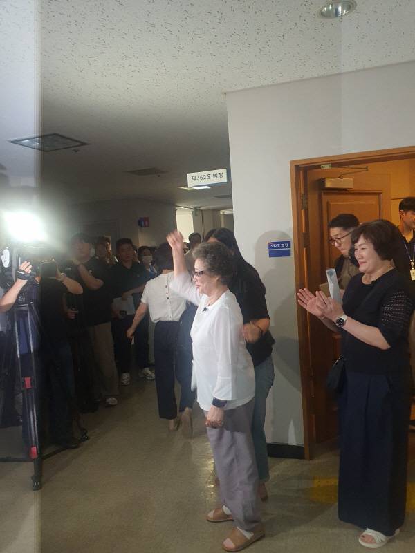 23일 부산지법 형사5부 심리로 열린 재심 사건에서 최말자 씨가 공판기일 종료 후 재판정을 나서며 손을 들어보이고 있다. 신심범 기자