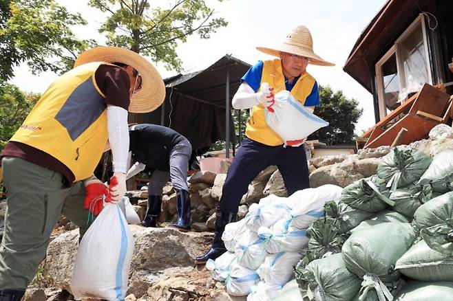 3일 충남 서산시 수해 피해 마을에서 환경정비활동을 펼치는 이성해 국가철도공단 이사장(오른쪽)과 직원봉사단. 국가철도공단