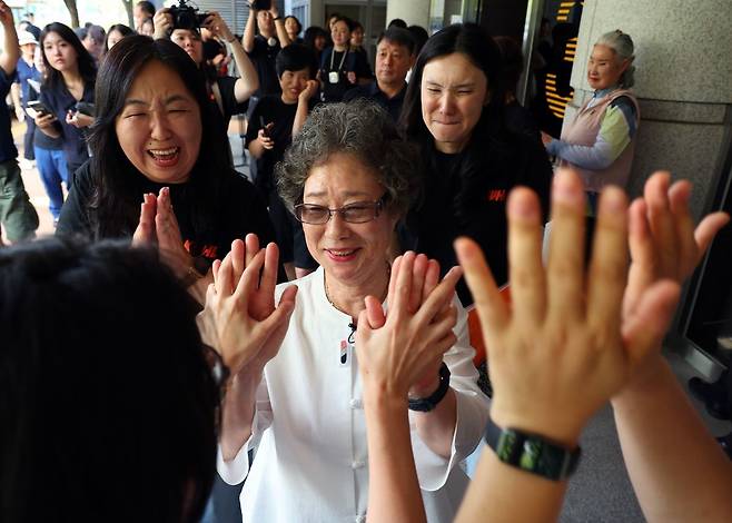 61년 전 자신을 성폭행하려던 남성의 혀를 깨물어 중상해 혐의 유죄 판결을 받았던 최말자(78)씨가 23일 부산지법에서 열린 재심 첫 공판을 마치고 법정을 나서며 변호인과 여성단체의 박수를 받고 있다. 연합뉴스