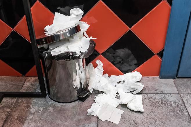 공중 화장실 쓰레기통이 각종 휴지 쓰레기로 넘친 모습.[123rf]