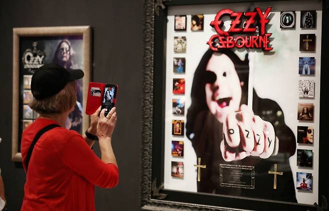 오지 오스본의 고별 공연인 블랙 사바스의 버밍엄 콘서트를 앞두고 2일(현지시간) 영국 버밍엄 박물관에서 열린 오지 오스본 전시에서 한 관람객이 휴대전화로 오스본의 사진을 촬영하고 있다. 2025.7.2 로이터 연합뉴스