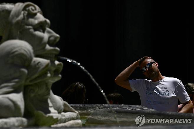 이탈리아 로마의 한 분수대에서 물로 머리를 식히는 관광객  [AFP 연합뉴스 자료사진]