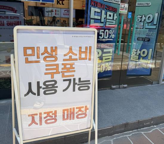 24일 진주 중안동에 위치한 한 휴대폰 판매장 앞에 '민생 소비 쿠폰 사용 가능' 문구를 내건 입간판이 세워져 있다.