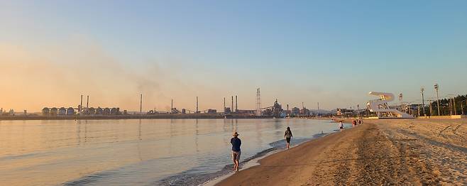 여명이 밝아오는 송도해수욕장 모랫길에서 맨발걷기를 하는 사람들.