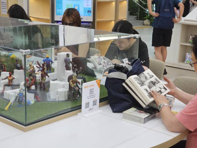 1층 만화라운지에 있는 디오라마 테이블. 연산로타리, 연산 고분군, 온천천 세병교 등 연제구의 상징적 장소와 만화 주인공들이 어우러진 조형물과 함께 만화책을 감상할 수 있는 공간이다.