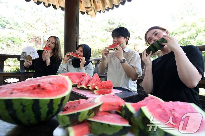 24일 오후 대구 달서구 계명대 성서캠퍼스 한학촌에서 열린 '외국인 유학생 여름나기' 행사에 참여한 학생들이 친구들에게 보여줄 수박 먹방을 선보이고 있다. 2025.7.24/뉴스1 ⓒ News1 공정식 기자