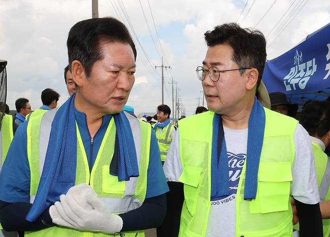 정청래(왼쪽), 박찬대 더불어민주당 당대표 후보가 21일 충남 예산 신안면 조곡리에서 수해복구 현장을 찾아 대화하고 있다./뉴스1