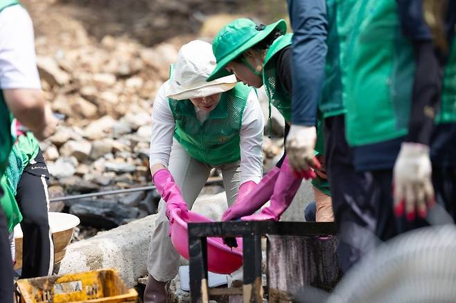 김혜경 여사가 24일 경기 가평군 백둔리 수해현장을 찾아 수재민을 위로하고 자원봉사자들과 봉사활동을 하고 있다. 대통령실 제공