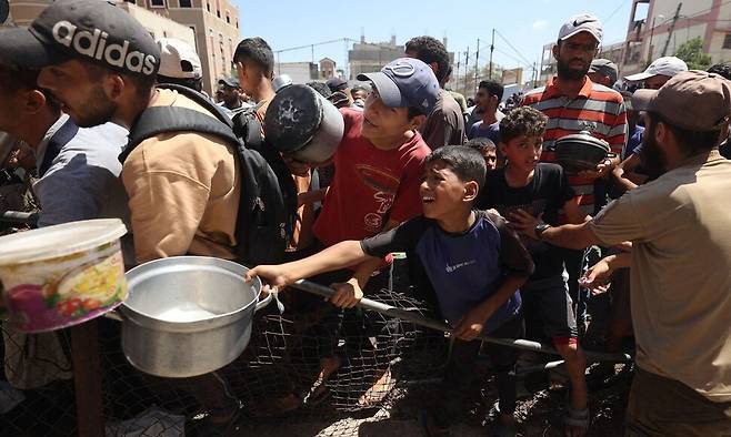 지난 19일 팔레스타인 주민들이 가자지구 중부 누세라이트 난민캠프의 식량 배급소에 모여 있는 모습. 세계식량계획(WFP)은 가자 주민 세명 중 한 명은 며칠씩 아무것도 먹지 못하고 있다며 “수천명”이 “재앙적인 기아 직전 상태”에 처해 있다고 밝혔다. AP연합뉴스