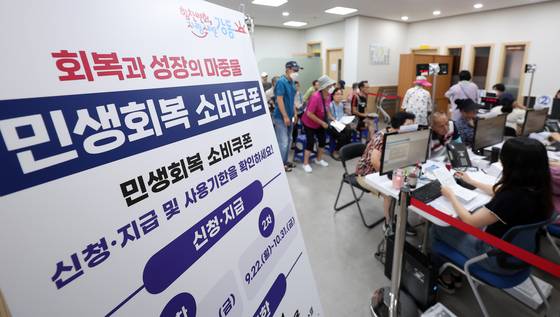 민생회복 소비쿠폰 1차 신청 둘째 날인 22일 서울 강동구 암사1동 주민센터를 찾은 시민들이 소비쿠폰을 신청하고 있다. [뉴스1]